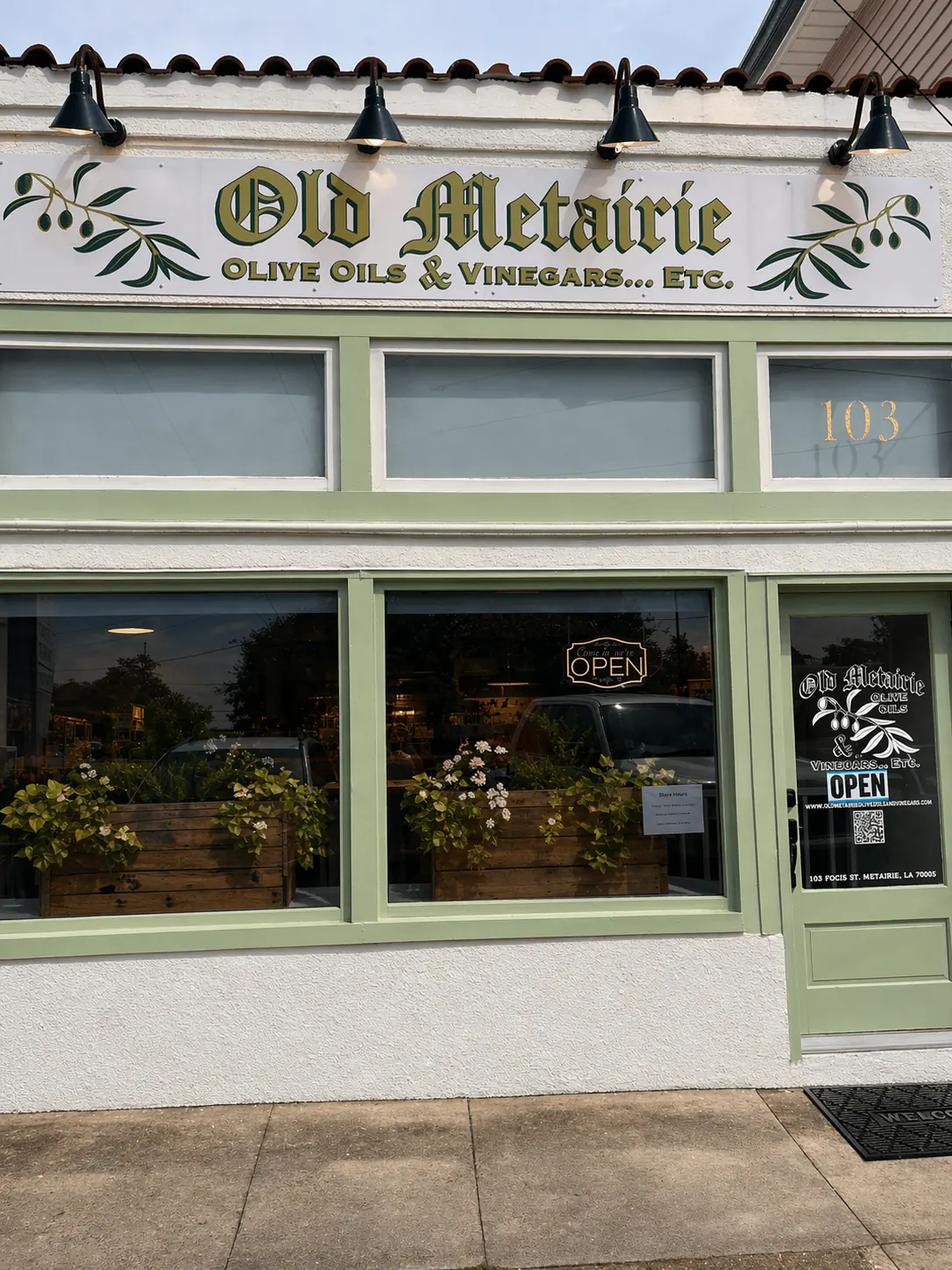 Old Metairie olive oil and vinegar storefront with green trim and Mediterranean style exterior